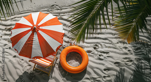 Beach scene with an orange and white umbrella, inflatable ring, and lounge chair on white sand, palm leaves partially covering the scene. Summer vacation concept.  Generative AI photo