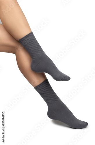 Female feet wearing grey cotton socks on white background