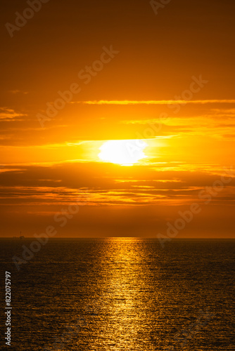 the sun rises over the ocean as the clouds hang low