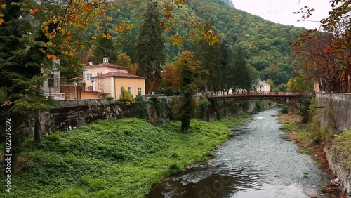 Riverfront buildings and Podul de Fonta on River Cerna on a cloudy day in Baile Herculane, Romania photo