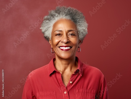Maroon Background Happy black american independant powerful Woman. Portrait of older mid aged person beautiful Smiling girl Isolated on Background ethnic diversity  © Zickert