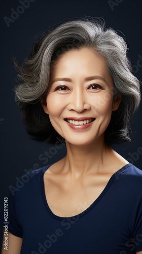 Navy Background Happy Asian Woman Portrait of Beautiful Older Mid Aged Mature Smiling Woman good mood Isolated Anti-aging Skin Care Face Beauty Product