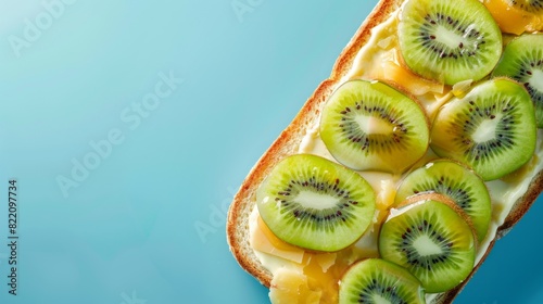 Loaf bread with cheese and kiwi topping, multigrain, flat lay, copy space solid background