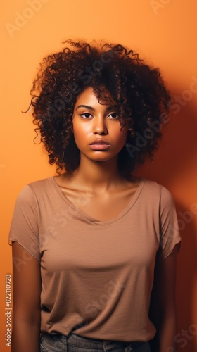 Peach background sad black independent powerful Woman. Portrait of young beautiful bad mood expression girl Isolated on Background racism skin color depression anxiety fear 