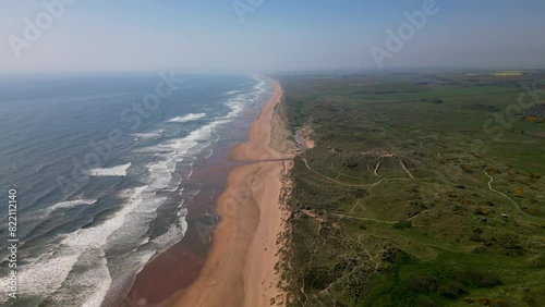 Aerial view over grassy sand dunes meeting the North Sea. Morning haze over Balmedie beach, Aberdeenshire.  photo