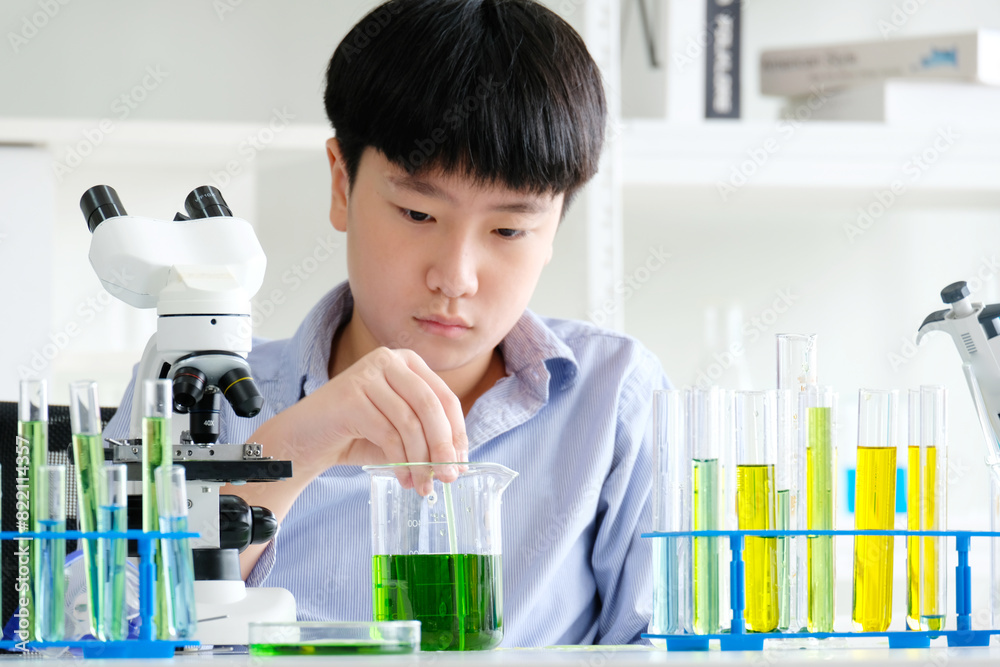 boy doing science experiment science classroom. boy doing science experiment science classroom.