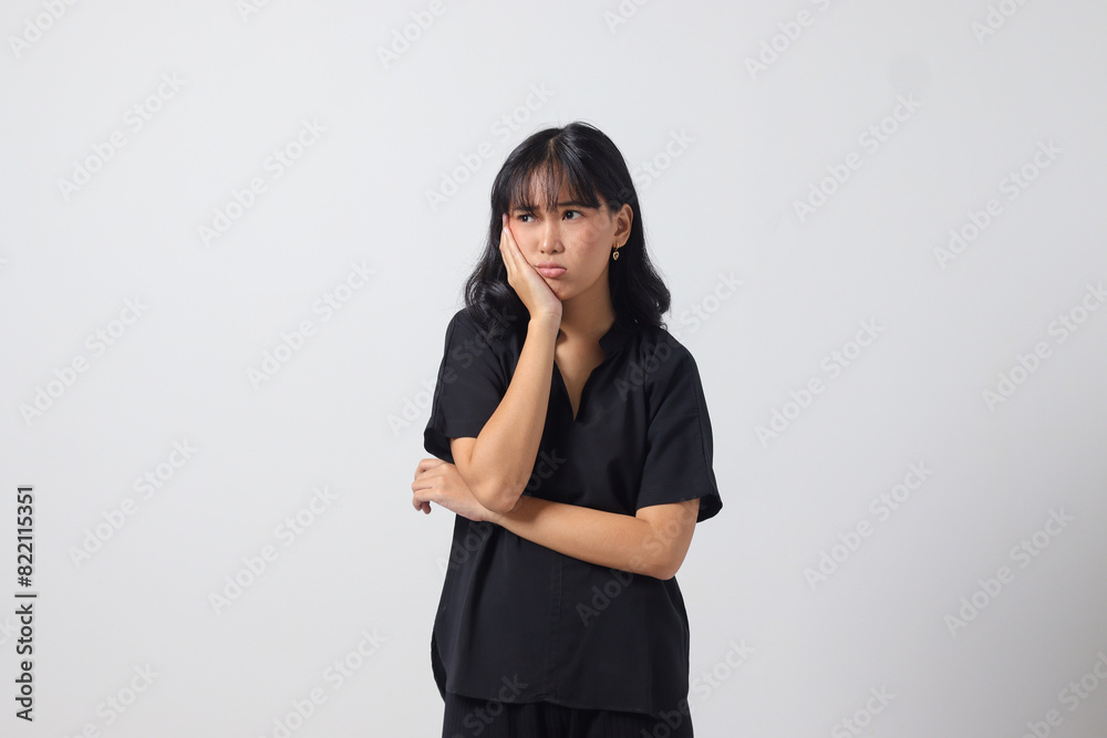 Portrait of unpleasant Asian woman in casual shirt keeping arms crossed and looking at camera with skeptical and distrustful look. Isolated image on white background Portrait of unpleasant Asian woman in casual shirt keeping arms crossed and looking at camera with skeptical and distrustful look. Isolated image on white background