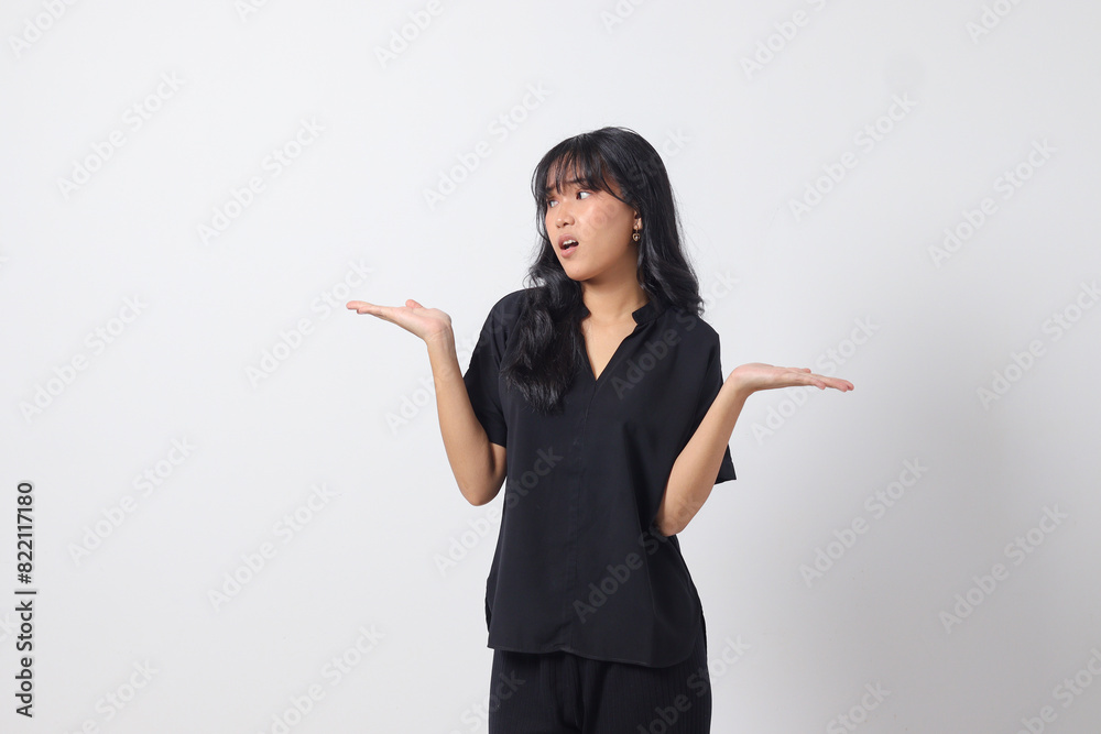 Portrait of excited Asian woman in casual shirt spreading hands making choice, choosing between two objects. Businesswoman concept. Isolated image on white background