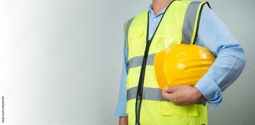 Civil engineer architect standing holding a safety helmet on grey background, Construction site plans to build high-rise buildings, Engineer building concept, Background for construction. Civil engineer architect standing holding a safety helmet on grey background, Construction site plans to build high-rise buildings, Engineer building concept, Background for construction.