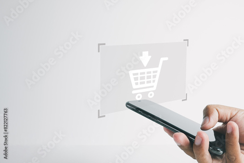 Modern E-commerce: Man Making Online Purchase via Smartphone with Shopping Cart App  Ideal for themes related to e-commerce, mobile shopping, and modern retail technology.