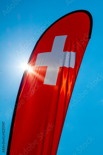 Swiss Banner Flag with Sunlight and Against Blue Sky in Switzerland.