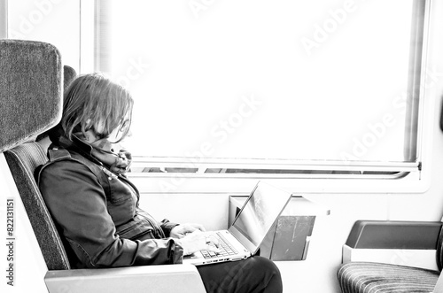 Woman Working on Laptop in Train in Switzerland.