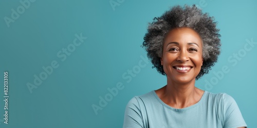 Teal Background Happy black american independant powerful Woman. Portrait of older mid aged person beautiful Smiling girl Isolated on Background ethnic diversity © Zickert
