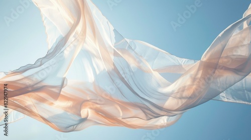 a soft translucent pink fabric against the sky flutters in the wind photo