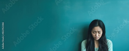 Turquoise background sad Asian Woman Portrait of young beautiful bad mood expression Woman Isolated on Background depression anxiety fear burn out health issue problem mental  photo