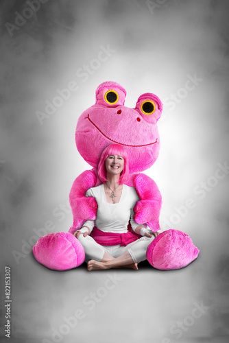 Portrait of a young woman with pink hair and a pink stuffed frog