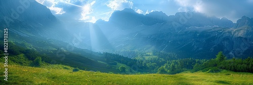 Majestic mountain landscape with lush green valley and dramatic clouds in bright sunlight 