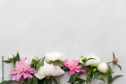 Pink and white peonies on a gray background. Minimalism. Top view. Space for text.