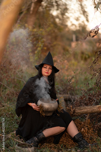 A witch dressed in black dress in the forest	