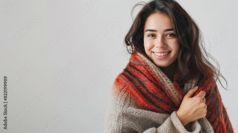 an isolated woman holding a scarf and smiling warmly, on a plain white background.