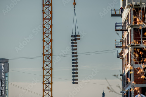 A tower crane lifted many buckets for concrete.
