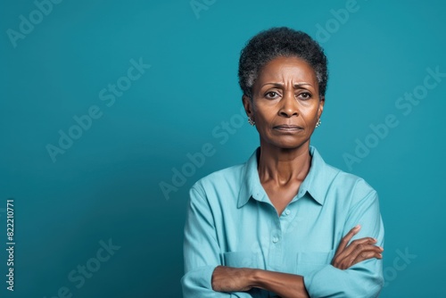 Cyan background sad black American independent powerful Woman. Portrait of older mid-aged person beautiful bad mood expression girl Isolated on Background racism skin color depression anxiety fear bur photo