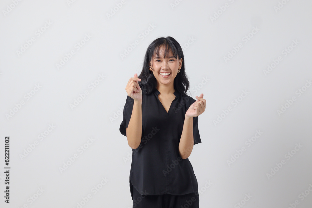 Portrait of attractive Asian woman in casual shirt making korean heart sign means love to you. Showing sympathy and caring feelings. Isolated image on white background Portrait of attractive Asian woman in casual shirt making korean heart sign means love to you. Showing sympathy and caring feelings. Isolated image on white background