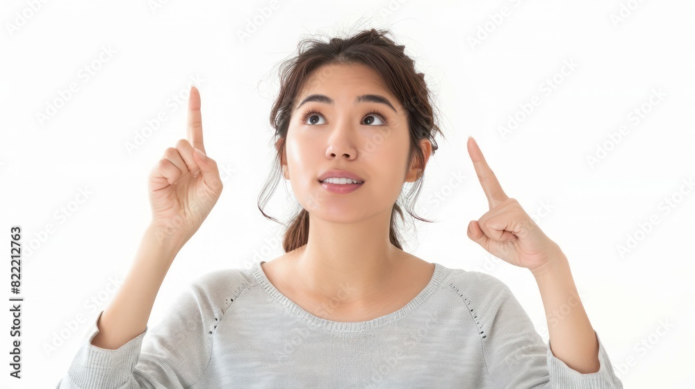 Asian woman pointing her hand up and looking above her head Asian woman pointing her hand up and looking above her head