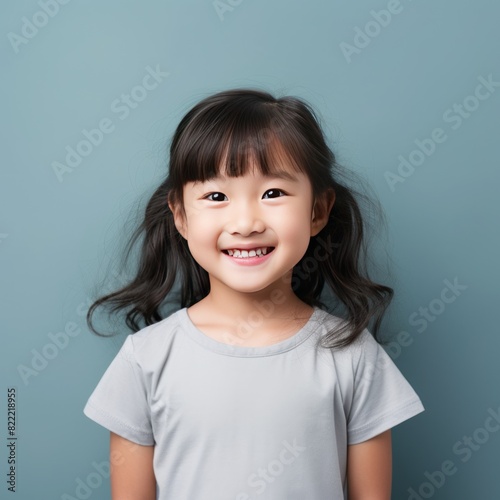 Gray background Happy Asian child Portrait of young beautiful Smiling child good mood Isolated on backdrop ethnic diversity equality acceptance 