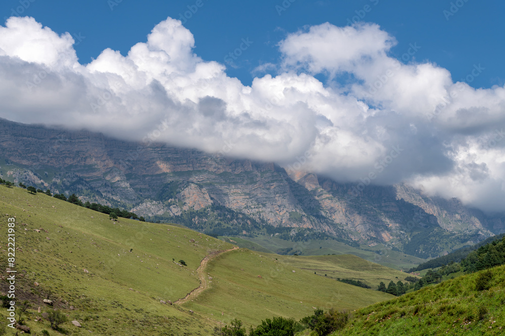 Clouds over the tops of the rocks. View of the Caucasus Mountains in Ingushetia, Russia Clouds over the tops of the rocks. View of the Caucasus Mountains in Ingushetia, Russia