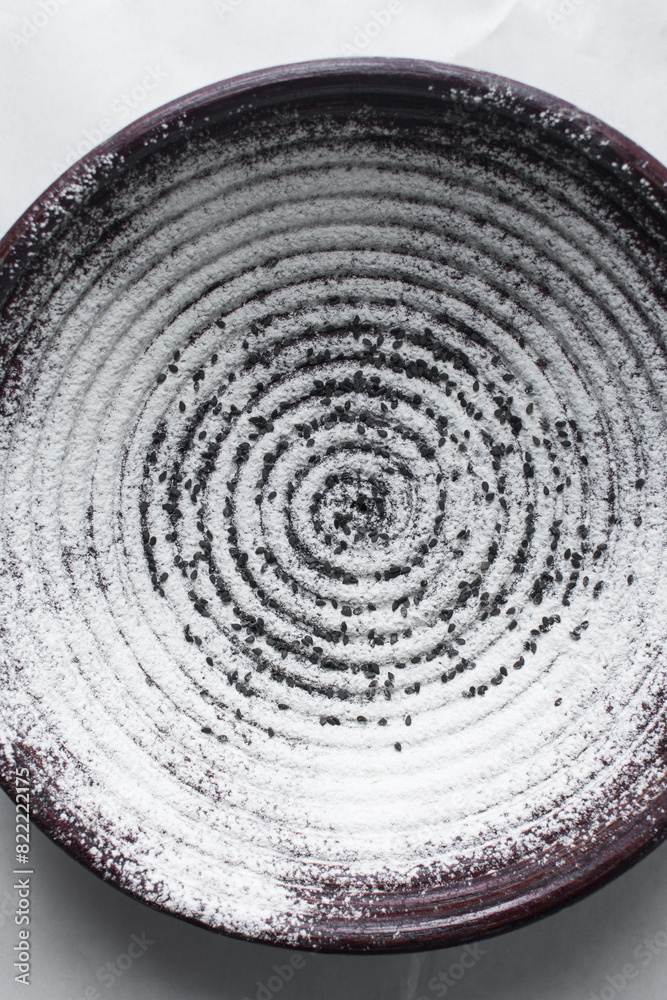 Naklejka premium Overhead view of floured banneton basket for bread making, Top view of a wood proofing basket