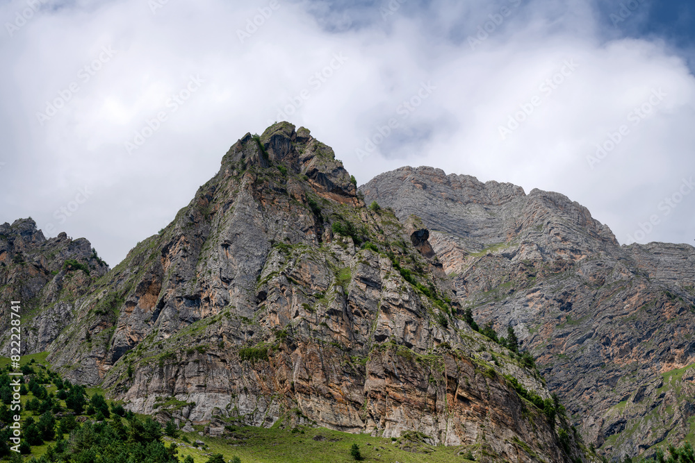Clouds over the tops of the rocks. View of the Caucasus Mountains in Ingushetia, Russia Clouds over the tops of the rocks. View of the Caucasus Mountains in Ingushetia, Russia