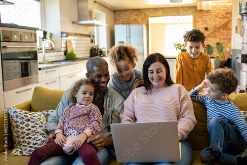 Family Using Laptop on Couch at Home photo