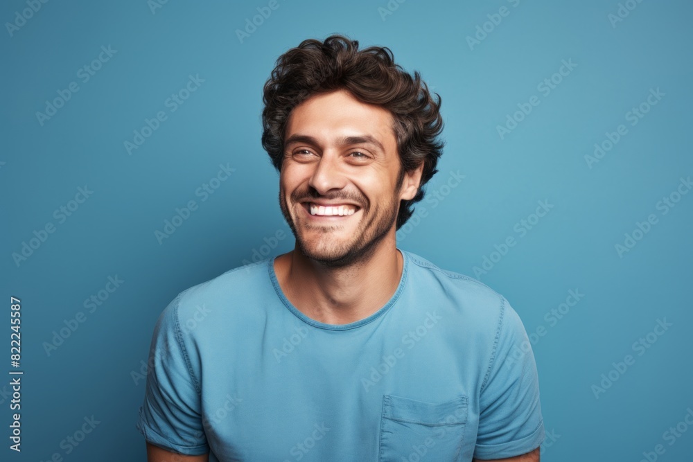 Portrait of a cheerful man in his 30s smiling at the camera isolated in blank studio backdrop