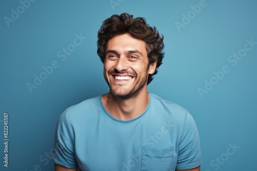Obraz na płótnie Portrait of a cheerful man in his 30s smiling at the camera isolated in blank studio backdrop w salonie