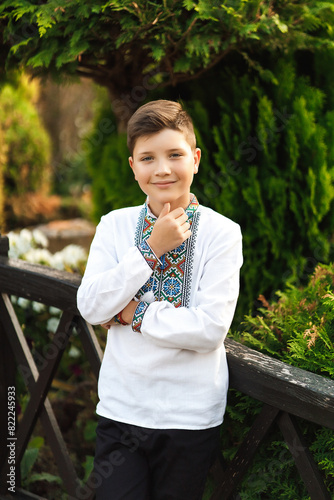Obraz na płótnie Young teenager in an embroidered shirt posing in a summer park w salonie