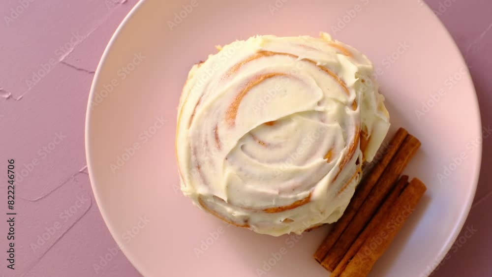 cinnamon roll on pink background and pink plate in close-up	