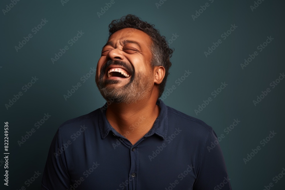 Portrait of a tender indian man in his 40s laughing isolated in blank studio backdrop Portrait of a tender indian man in his 40s laughing isolated in blank studio backdrop