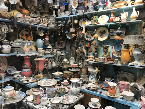 Vibrant Eclectic Display of Intricate Ceramics and Vintage Items in Charming Rustic Store | Pottery, Teapots, Teacups, Plates & Figurines with Floral and Geometric Designs | Nostalgic Cozy Antique photo