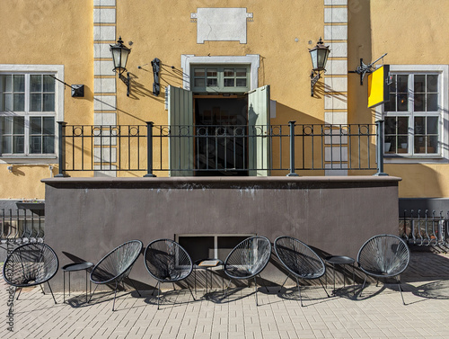 Wicker chairs and small tables in a street outdoors cafe in the old town of Riga, Latvia.