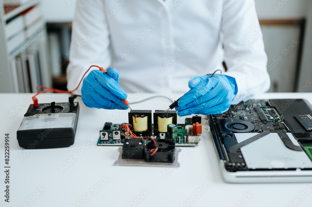 Obraz premium Electronics technician, electronic engineering electronic repair,electronics measuring and testing, repair and maintenance concepts.uses a voltage meter to check and upgrade