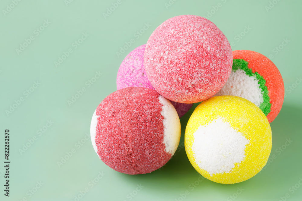 Five colorful bath bombs on a light green background. Copy space. Photo Five colorful bath bombs on a light green background. Copy space. Photo