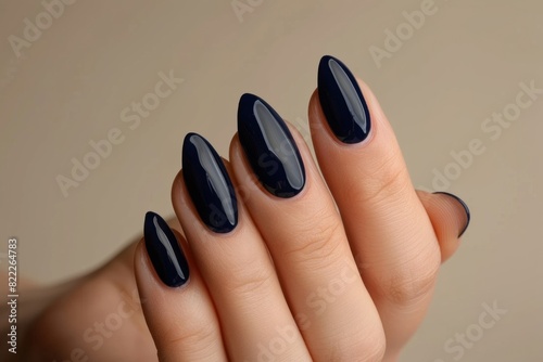 Woman s Hand With A Deep Blue Nail Polish On Her Long Almond Shaped Nails Nail Salon Beige Background
