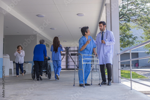 doctor or nurse helping Senior Woman to walk at nursing home with walker. Doctor or nurse helping old elderly Woman grandfather to walk using walker equipment