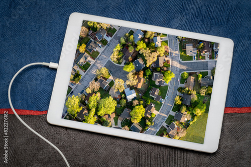 spring sunrise over residential area of Fort Collins in Colorado, reviewing an aerial image on a tablet