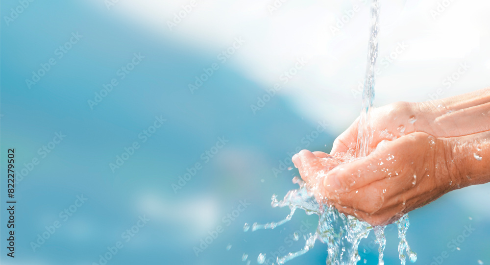 Fototapeta premium Frisches Trinkwasser fliesst über menschliche Hände