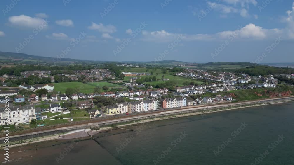 Dawlish, South Devon, England: DRONE VIEWS: The drone circles pastel-coloured Victorian terrace houses on the seafront; countryside in the background. Dawlish is a popular UK holiday resort (Clip 1). Dawlish, South Devon, England: DRONE VIEWS: The drone circles pastel-coloured Victorian terrace houses on the seafront; countryside in the background. Dawlish is a popular UK holiday resort (Clip 1).