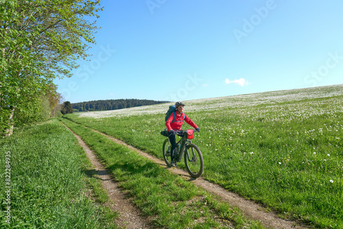 active senior woman on a bike packing tour with her electric mountain bike in the Bavarian Forest near Waldkirchen, Bavaria, Germany 
