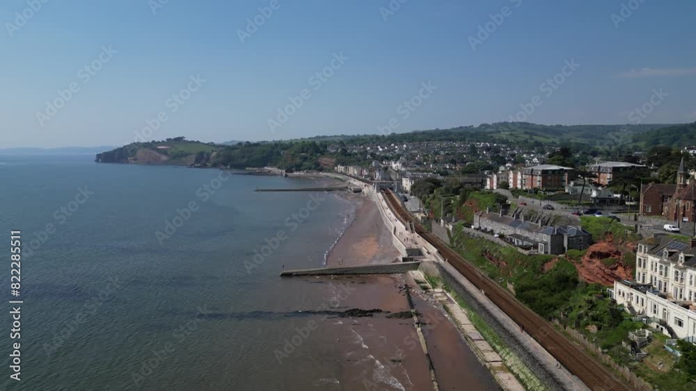 Dawlish, South Devon, England: DRONE VIEWS: The coastline at Dawlish featuring the railway track and station, the beach, sea, houses and town quay. Dawlish is a popular UK holiday resort (Clip 6). Dawlish, South Devon, England: DRONE VIEWS: The coastline at Dawlish featuring the railway track and station, the beach, sea, houses and town quay. Dawlish is a popular UK holiday resort (Clip 6).