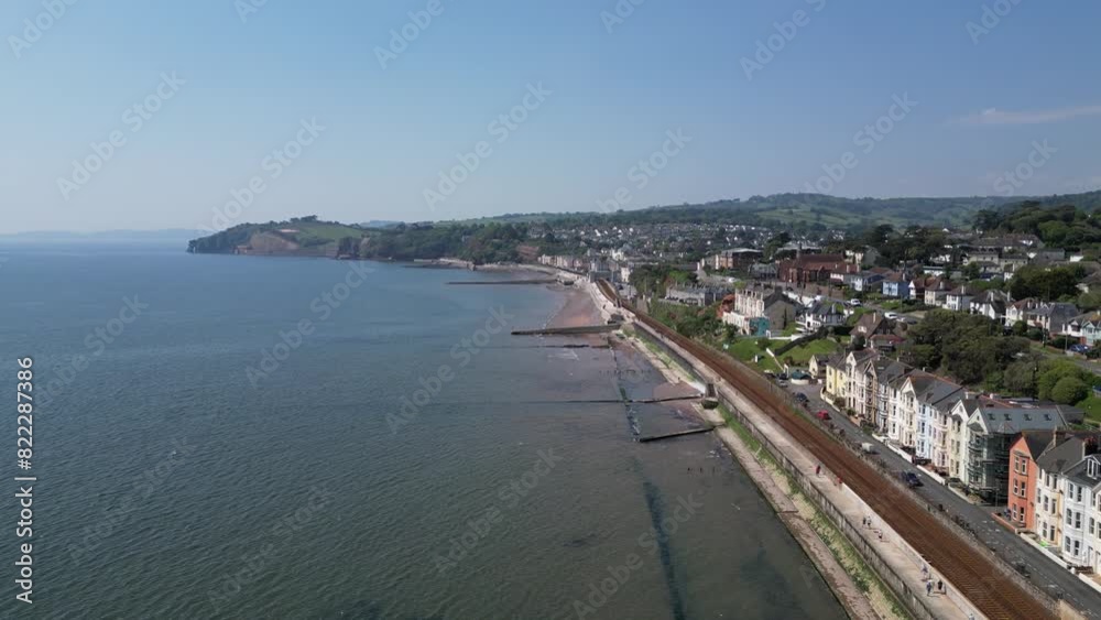 Dawlish, South Devon, England: DRONE VIEWS: The coastline at Dawlish featuring the railway track and station, the beach, sea, houses and town quay. Dawlish is a popular UK holiday resort (Clip 4). Dawlish, South Devon, England: DRONE VIEWS: The coastline at Dawlish featuring the railway track and station, the beach, sea, houses and town quay. Dawlish is a popular UK holiday resort (Clip 4).